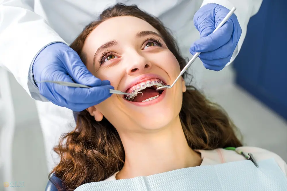 a person being examined for her braces by an orthodontist wearing gloves. braces cost in Indianapolis, IN