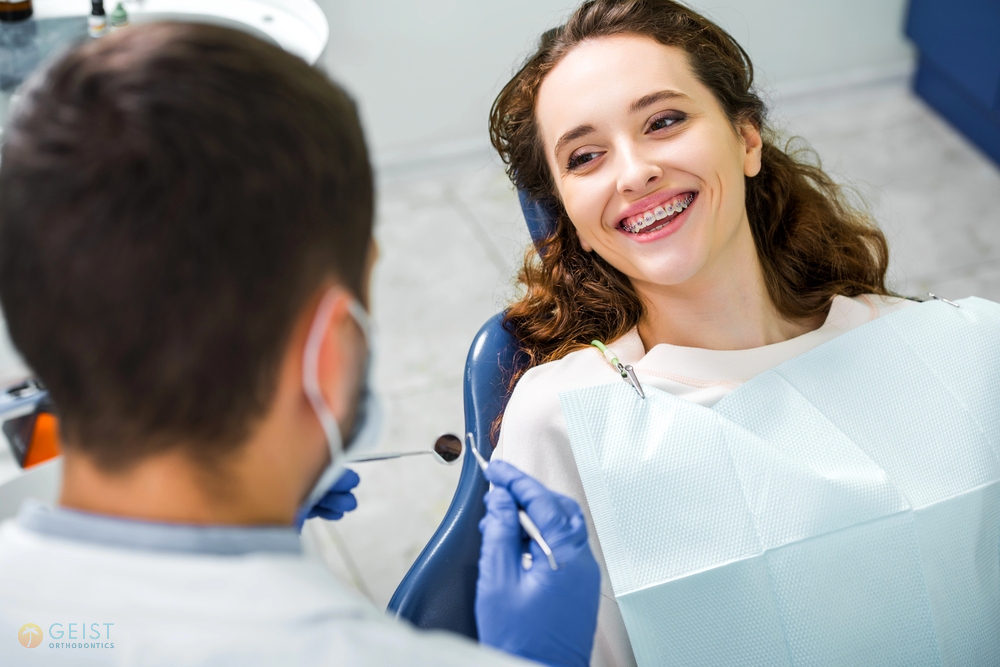 a woman smiling in blue bib after being explained about how long do braces take in indianapolis, in